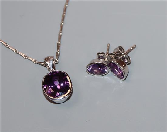 A modern white metal and amethyst suite of jewellery, comprising a pendant on 750 chain and a pair of 750 set earstuds.